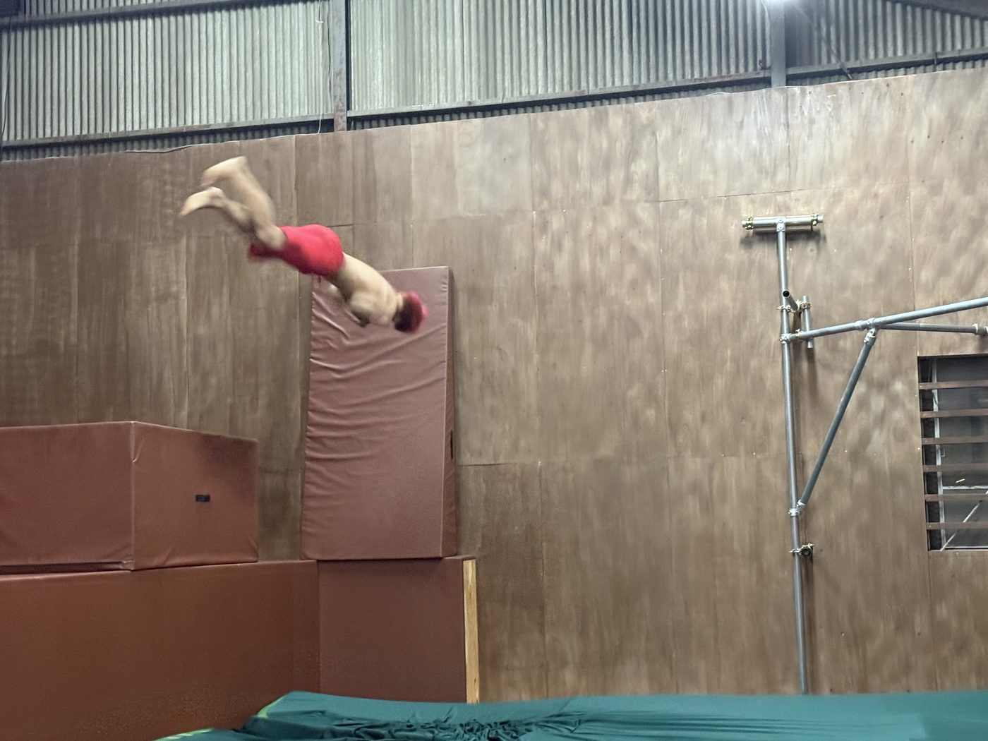 An adult diving into the foam pit during training at PK Guild