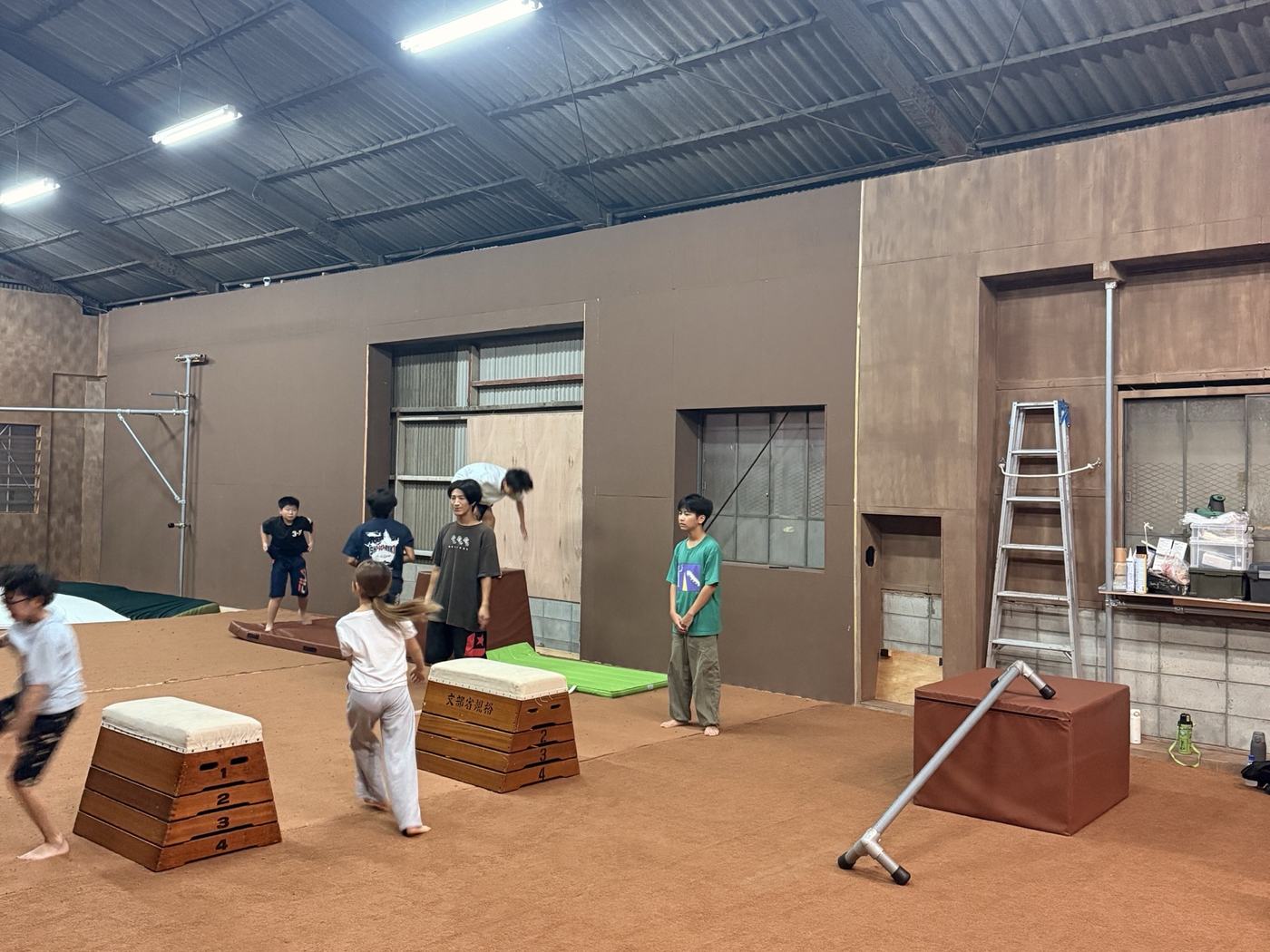 PK Guildの施設で、跳び箱と箱を使って練習する子どもたちと講師